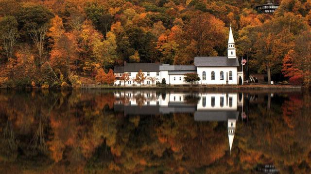a gorgeous image of St. John's Church, from Cold Spring Harbor, Long Island. The image shows the church and its reflection in the adjacent pond, with fall folliage all around.