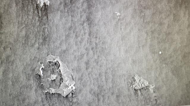Black and white island which is a volcano, ocean