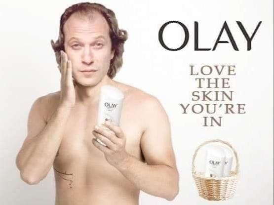 An Olay ad featuring Jame Gumb aka Buffalo Bill from Silence of the Lambs. he rubs lotion on his skin with the words "Olay love the skin you're in"