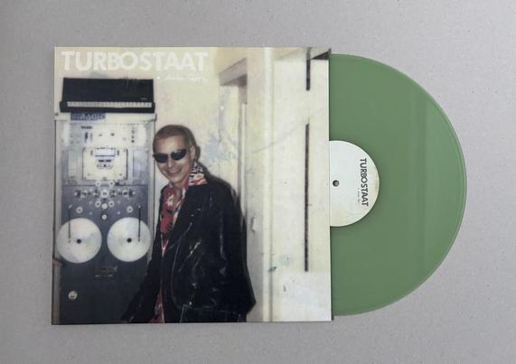 Das Albumcover ziert das etwas unscharfe Foto eines jungen Mannes (Moses Schneider) in Lederjacke, buntem Hemd & Sonnenbrille vor einem Tonbandgerät in einem Tonstudio. Er grinst richtung Kamera. Eine Schallplatte schaut zur Hälfte aus dem Sleeve heraus. Sie ist  in einem grün-grauen Farbton und transparent.