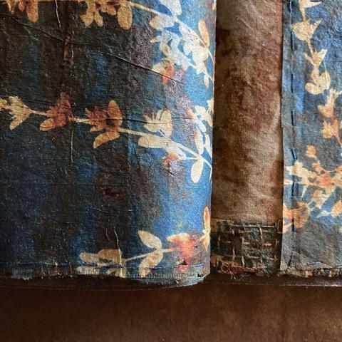 Image of sewn book pages made from cyanotype printed teabags covered in rust