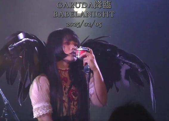 Garuda singing into mike. Black wings.