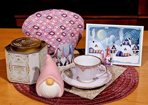 Tea tableau in shades of pink with little gnomes, a snow scene, and gingerbread black tea.