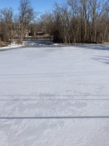 Frozen river covered in new snow.