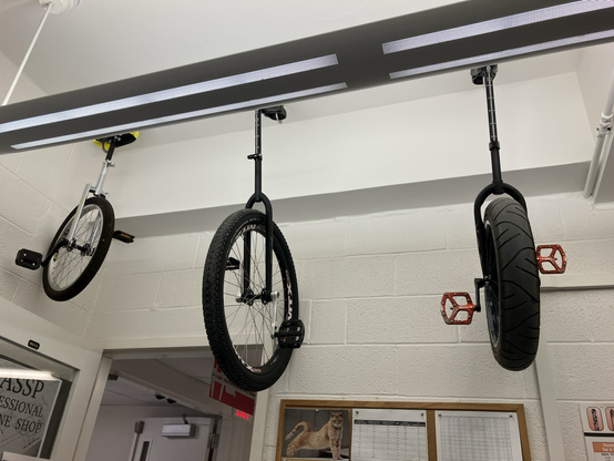 Image of unicycles hanging from the ceiling of my office.