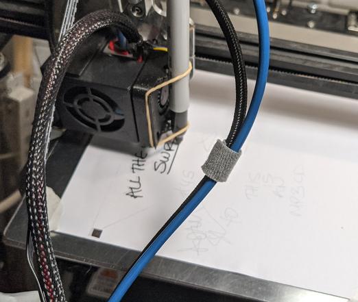 A 3d printer with a Sharpie rubber-banded to it begins writing onto a piece of paper