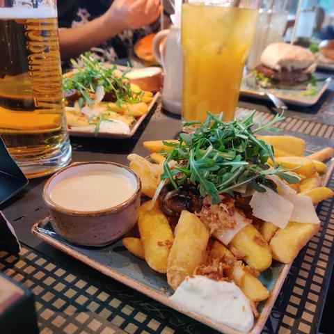 Champion Fritten, mit Rucola und diversen Soßen.