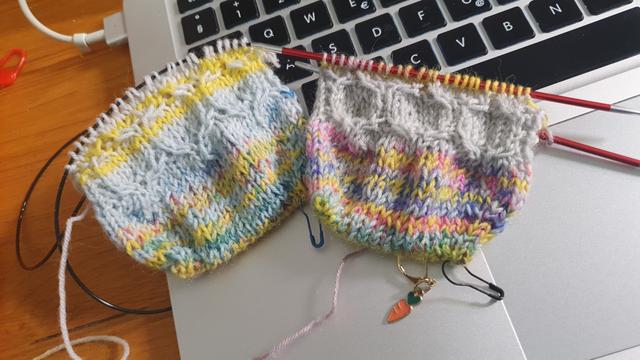 Beginning of a pair of toe up socks with a cable pattern in self striping yarn,background is a computer keyboard
Début d'une paire de chaussettes commencées par la pointe en laine autorayante, posées sur un clavier d'ordinateur