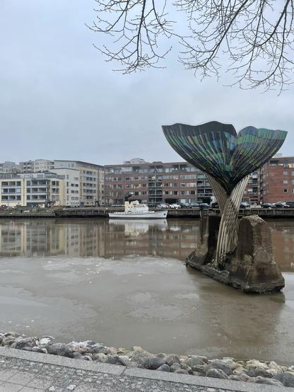 Aurajoki. Valaan pyrstö -taideteos. Hinaaja. Kerrostaloja.