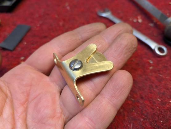 Plektrumhalter aus Messing auf einer Hand