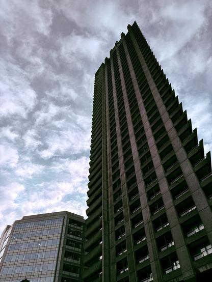 High rise building seen from below beneath a moody sky