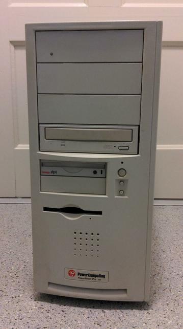 A tall desktop computer tower with four 5 1/4" drive bays at the top, the bottom of which has a plain CD reader in it and the top of which has a small clear spot for an activity LED. There are two 3 1/2" bays, the upper of which has an Iomega Zip drive in it. To the right of those are power and reset buttons. Below the 3 1/2" bays is 3 1/2" floppy drive with paperclip hole. Below that is a speaker grill and then the PowerComputing logo and PowerComputing PowerTower Pro 225
