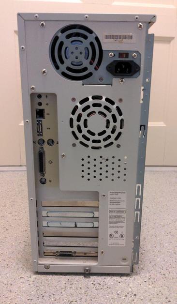 The back of an ATX tower computer case, showing the PSU at the top with switchable input and IEC inlet. Five of the six slots are blanked out and the bottom one has a Mac video connector. From top to bottom, the ports are mic, speaker, ethernet, AAUI, two mini-DIN serial, SCSI, and ADB.