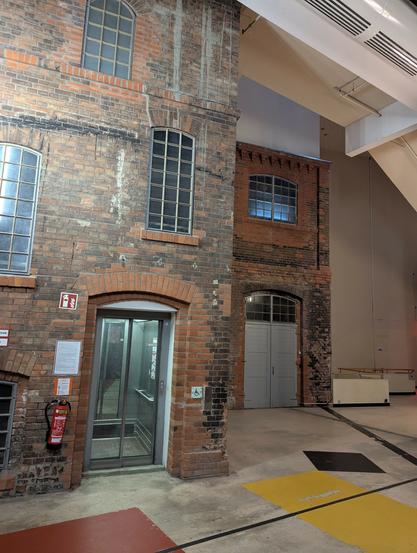 While normal two-storey brick buildings can be seen inside the cinema main hall, the relatively small height suggests the new cinema building around it is much, much taller.