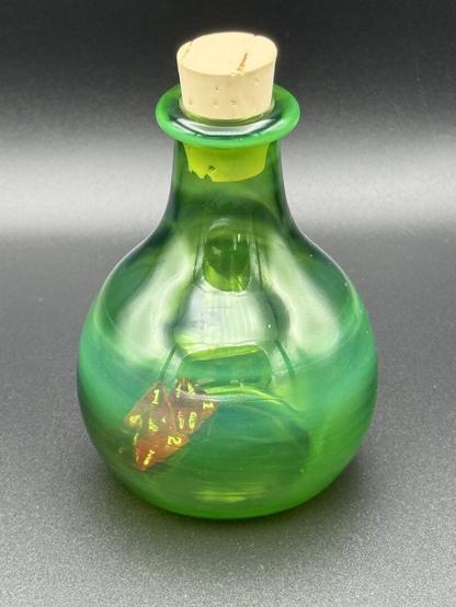 Green opalescent glass bottle with miniature 4 sided dice inside