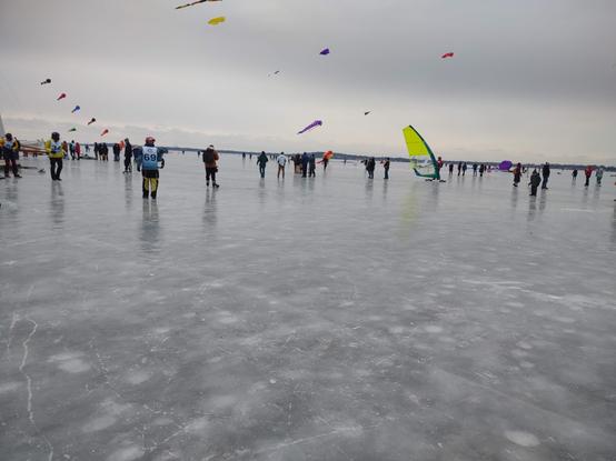 People flying kites on a frozen lake