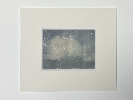 A polaroid transfer onto Arches platine paper. A picture of a wave crashing into rocks. Mounted with acid free carbon paper