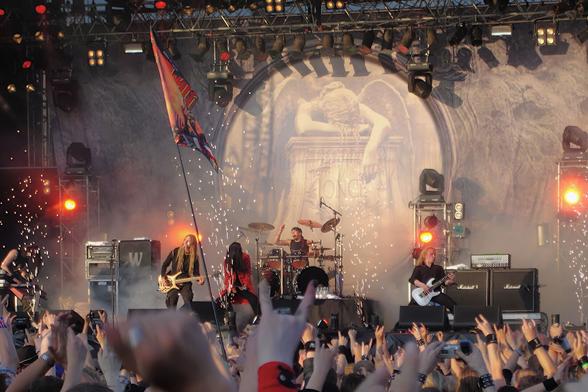 Nightwish esiintymässä Tuskan päälavalla 2004. Kuvan alalaidassa paljon yleisöä takaa päin nähtynä. Lähes kaikilla on kädet ylhäällä osoittamssa suosiota bändille. Kuvassa näkyy kaikki bändin jäsenet. Taustalla on Once-levyn kansikuva lavan korkuisessa lakanassa. Lavan etulaiden pyrojen tulisuihkut ovat juuri hiipumassa pois.