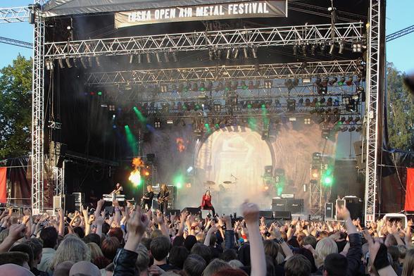 Nightwish esiintymässä Tuskan päälavalla 2004. Kuvan alalaidassa paljon yleisöä takaa päin nähtynä. Lähes kaikilla on kädet ylhäällä osoittamssa suosiota bändille. Kuvassa näkyy kaikki bändin jäsenet. Taustalla on Once-levyn kansikuva lavan korkuisessa lakanassa.