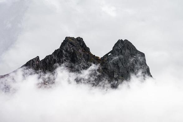 The jagged peaks of Vestrahorn emerge from thick fog, partially obscured by swirling mist. Captured along Iceland’s southern Ring Road near Stokksnes, this moody scene highlights the region’s ever-changing weather conditions.