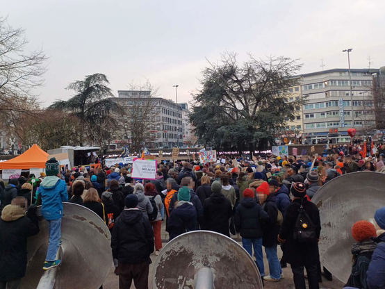 Hunderte Teilnehmer*innen stehen vor der Brunnen-Skulptur am Kölner Ebertplatz