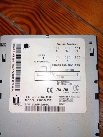 A closeup  of the label on top of an internal Zip drive, showing Iomega and Apple logos, plus SCSI ID settings. Model: Z100Si ZIP.