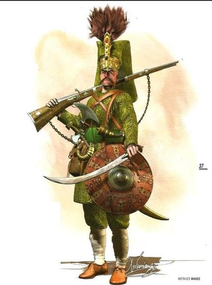 Ottoman soldier (possibly a janissary). He's got a front loading rifle and a small hatchet, a scimitar-like sword and a shield. Green uniform with a lot of elaborate embroidery, massive hat, leather straps everywhere, a feather brush adorning the hat, and gold trim everywhere.