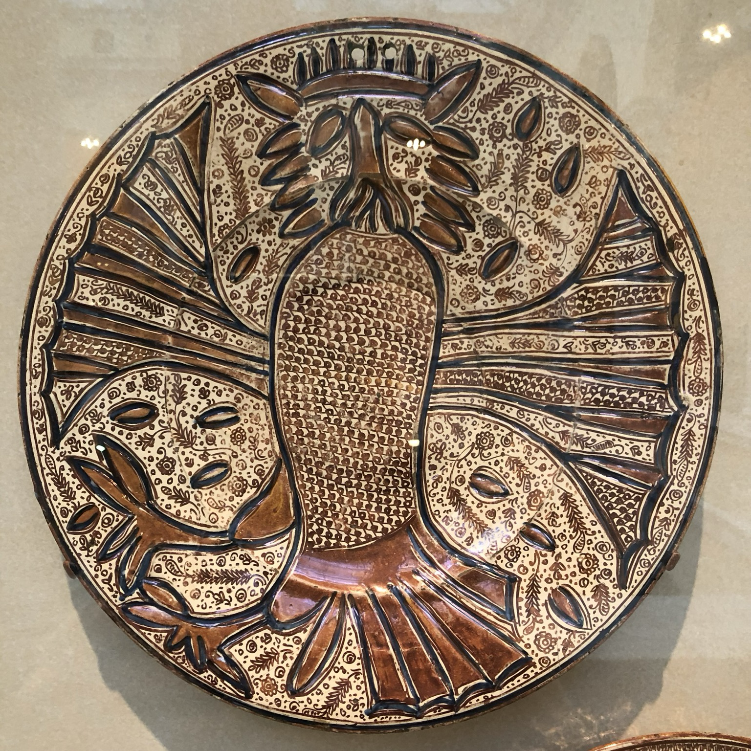 Photo of the owl plate hanging on display at museum