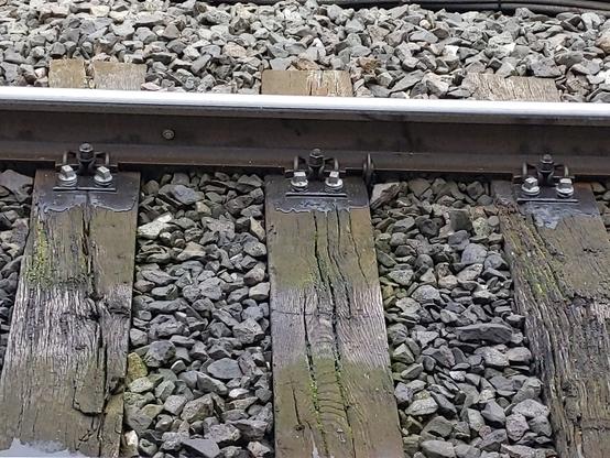 Traverses de chemin de fer. Un produit épais a été appliqué sur les vis des attaches au rail.