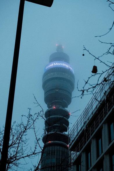 Very gloomy look up at the BT tower with it's top hidden by fog.