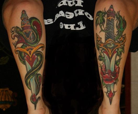 2 stylish dagger forearm tattoos. one with a snake wrapped around it. The other with a rose & vine and an eye on the handle.