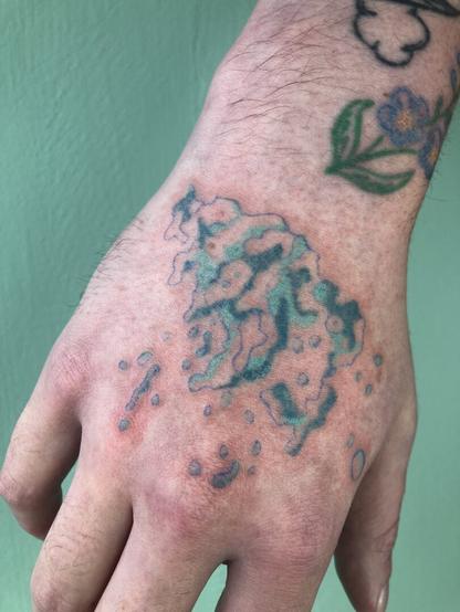 tatouage de vague turquoise, au handpoke sur une main