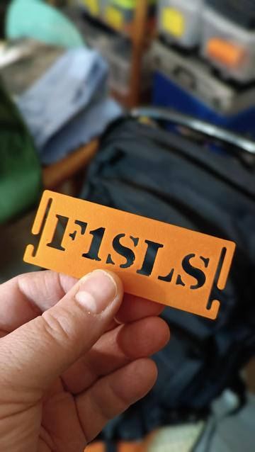 The tag in my hand before the backpack blurry in the background.
