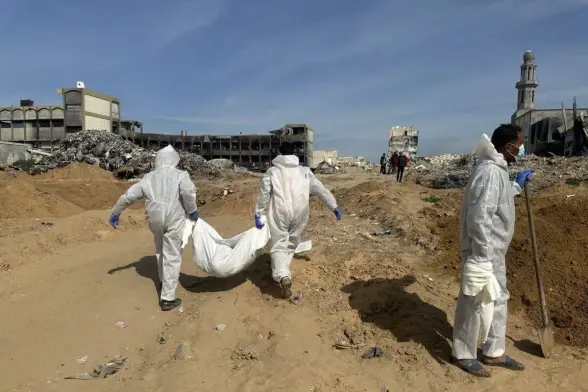 Officials, wearing protective suits, exhume bodies Palestinians, killed during Israeli raids on Sheikh Zayed in Northern Gaza, Gaza on February 02, 2025 [Hasan N. H. Alzaanin – Anadolu Agency]