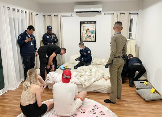 Deux suspects sont assis regardant la perquisition lors de l'opération « Phobos Aetor ». La scène se déroule à Phuket en Thaïlande. Les policiers récupère de nombreuses preuves et pièces à conviction.