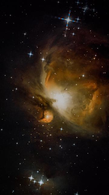 A vibrant image of a nebula in space, featuring swirling clouds of gas and dust illuminated by stars. The background is dotted with numerous bright stars against a dark backdrop, showcasing cosmic beauty.