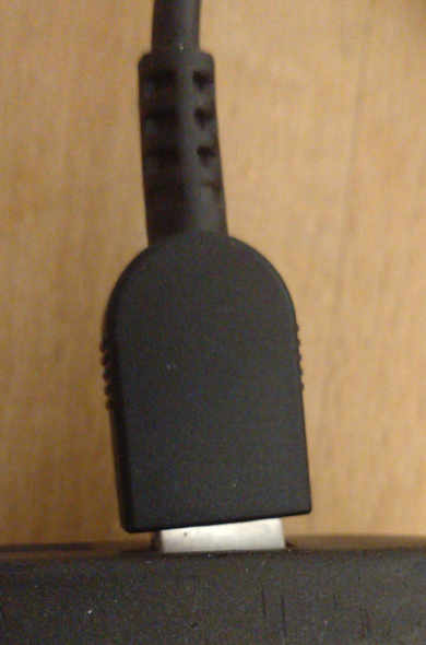 Ein Thinkpad-Ladekabel steckt schräg und nicht vollständig in seiner Buchse.