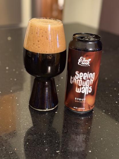 A stout glass full of dark beer with a massive dark tan head. The pint can is black with swirling tan and brown coffee patterns and white lettering.