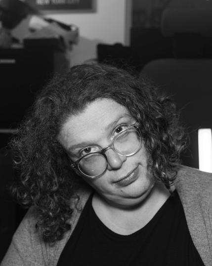A black and white photo of gemma staring over her glasses at the camera