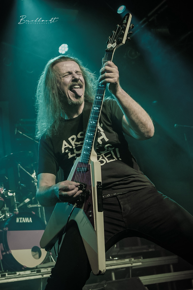 Vito auf der Bühne mit Flying-V Gitarre, Zunge raus, Rock’n’Roll Pose