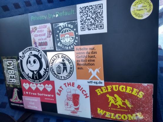 Mein zugestickerter Laptop, ich beziehe mich v.a. auf den Sticker der WTF-EG.de mit der Aufschrift "Arbeite nur, wenn du das Gefühl hast es löst eine Revolution aus."