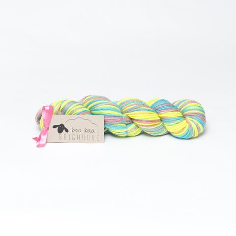 Picture shows a skein of yarn in shades of bright yellow, blue and pink.