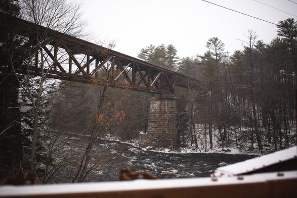 A train bridge that goes over a rushing river of water