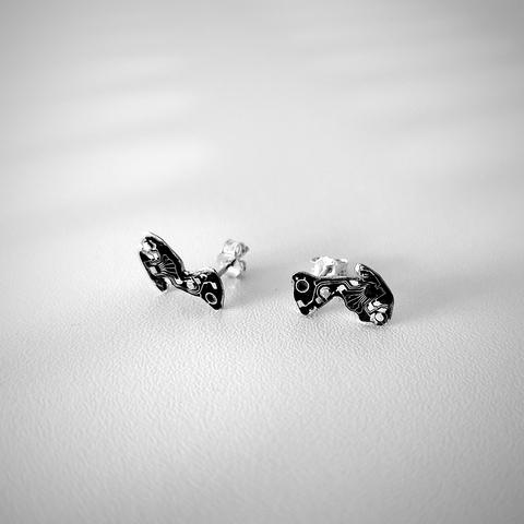 a pair of small stud earrings with an old tiny PCB. the photo is black and white