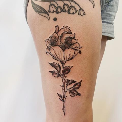 a tattoo of a heart blooming from a flower