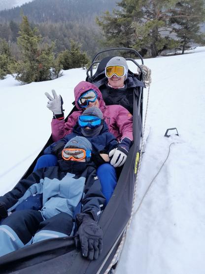 The 4 of us (2 adults+2 kids) inside the sled 
All in winter ski clothes with protective masks