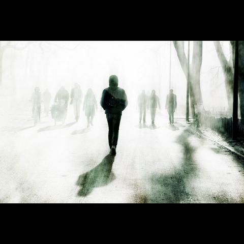 Un homme seul et son hombre qui marchent à contre jour vers la lumière. Lyon, France