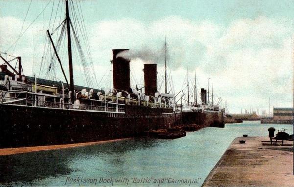 Two steamships are docked under cloudy skies. Each ship has two funnels each.