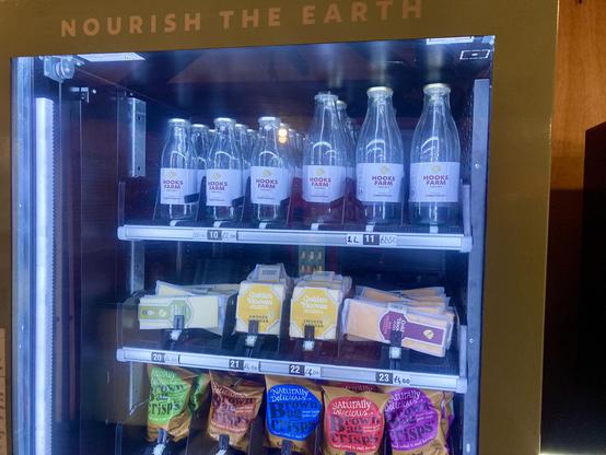 vending machine with glass bottles, cheese and crisps (eggs too, out of shot)