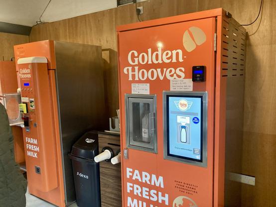 bright orange milk vending machines at farm shop